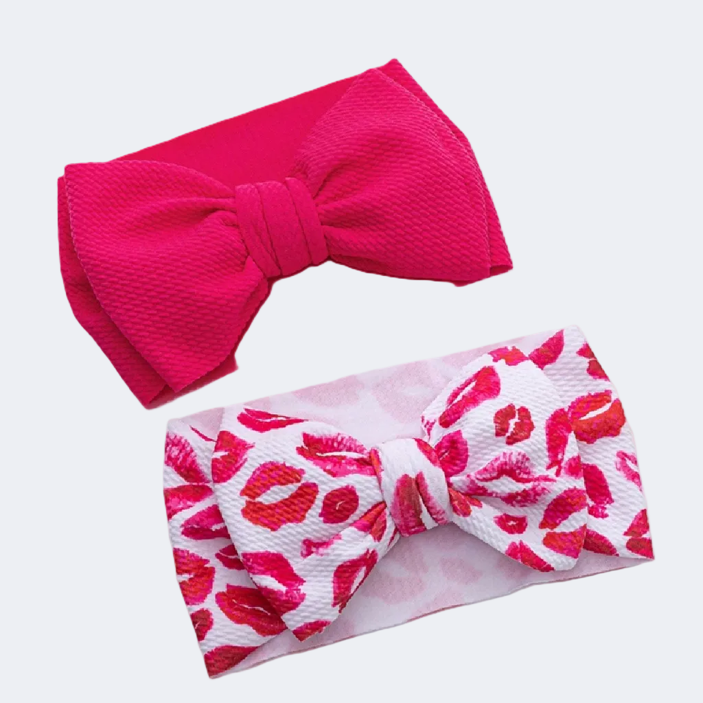 Two headbands with large bows, one pink and one with a red and white pattern, on a white background.