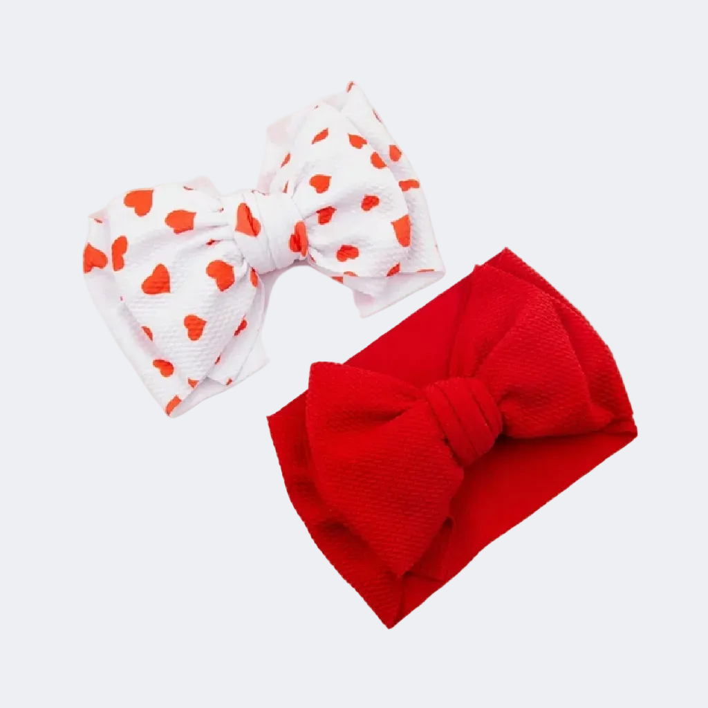 Two headbands, one red with a bow and one white with red heart patterns