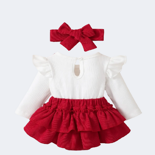 White top with ruffled sleeves and red skirt on a fluffy white surface.