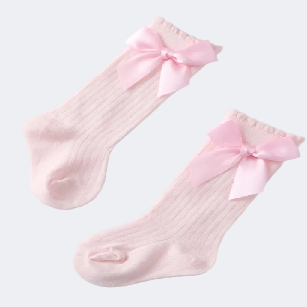 Two pink socks with bow details on a light gray background