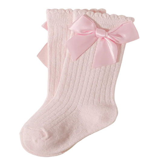 Two pink socks with bow details on a light gray background