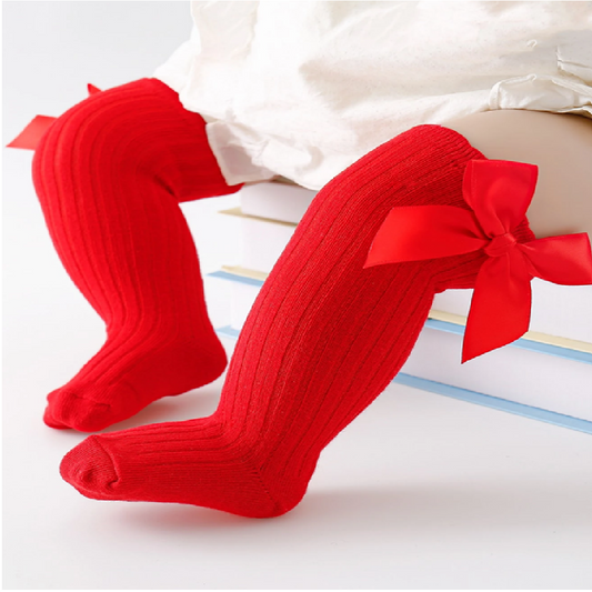 Red knee-high socks with bows worn by a child