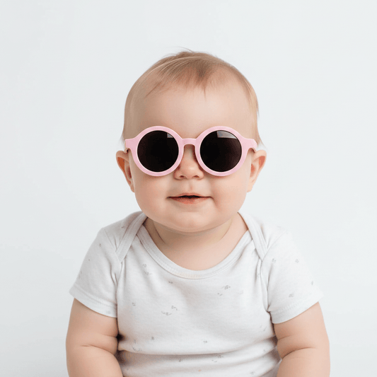 Baby wearing pink sunglasses on a white background