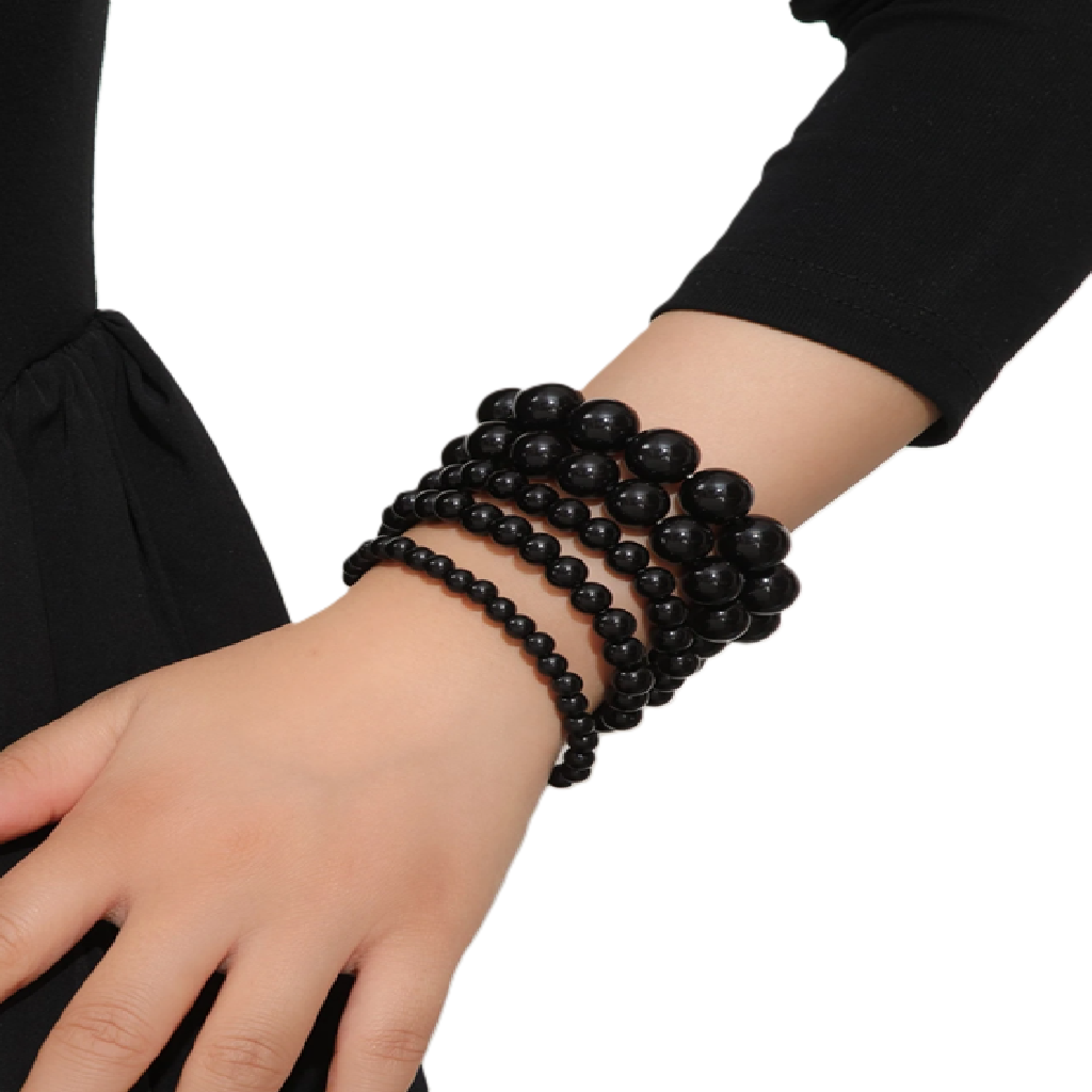 Black beaded bracelet on a wrist with a plain background
