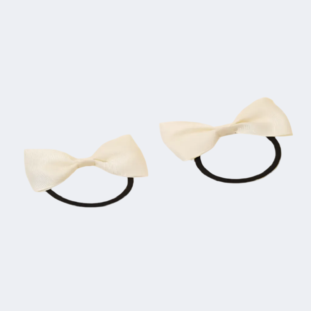 Two beige hair bows with black elastic bands on a white background
