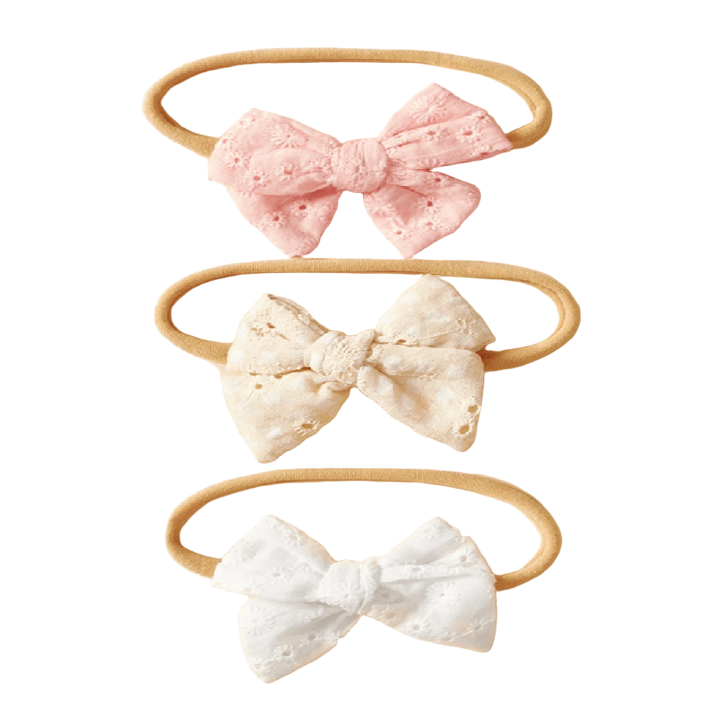 Three headbands with lace bows in pink, white, and beige