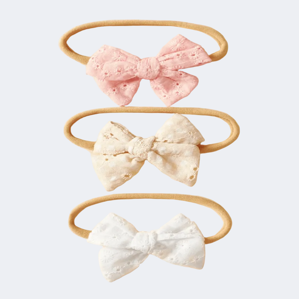 Three headbands with lace bows in pink, white, and beige