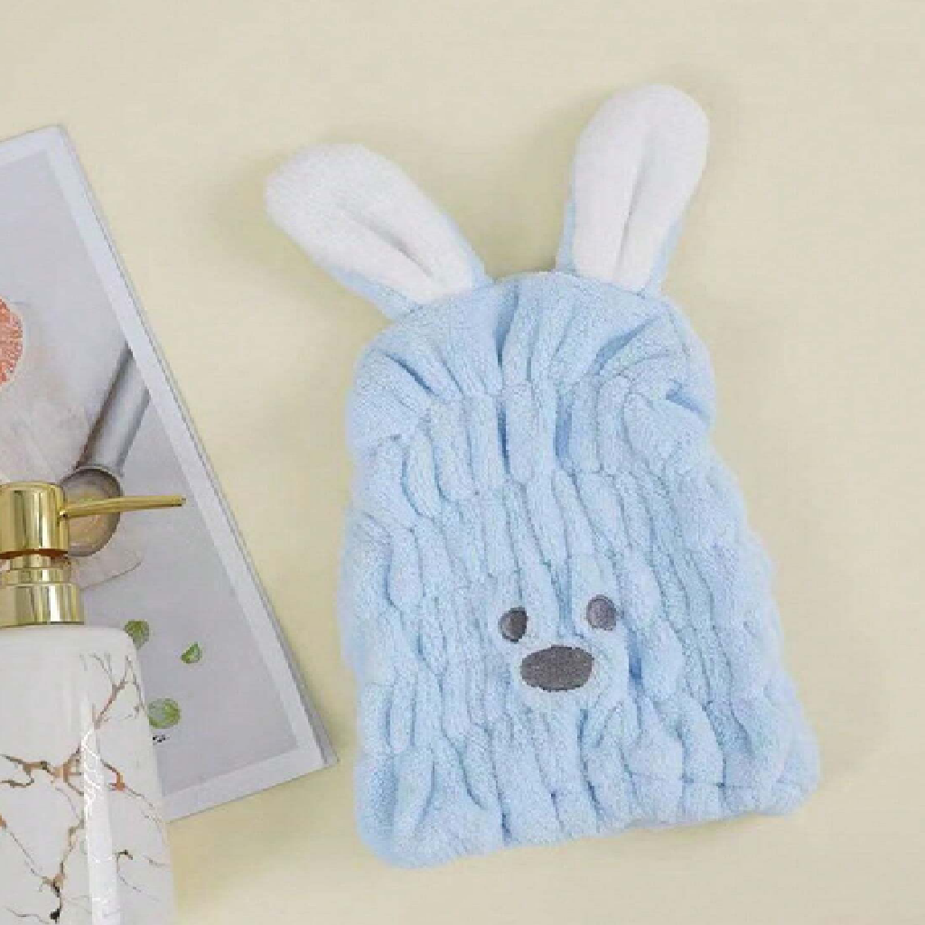 Blue towel with bunny ears and face on a beige background