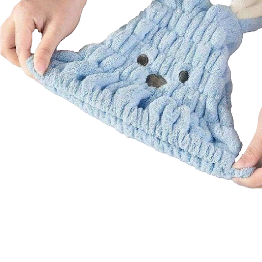 Blue knitted dog toy with a face design held by hands on a white background