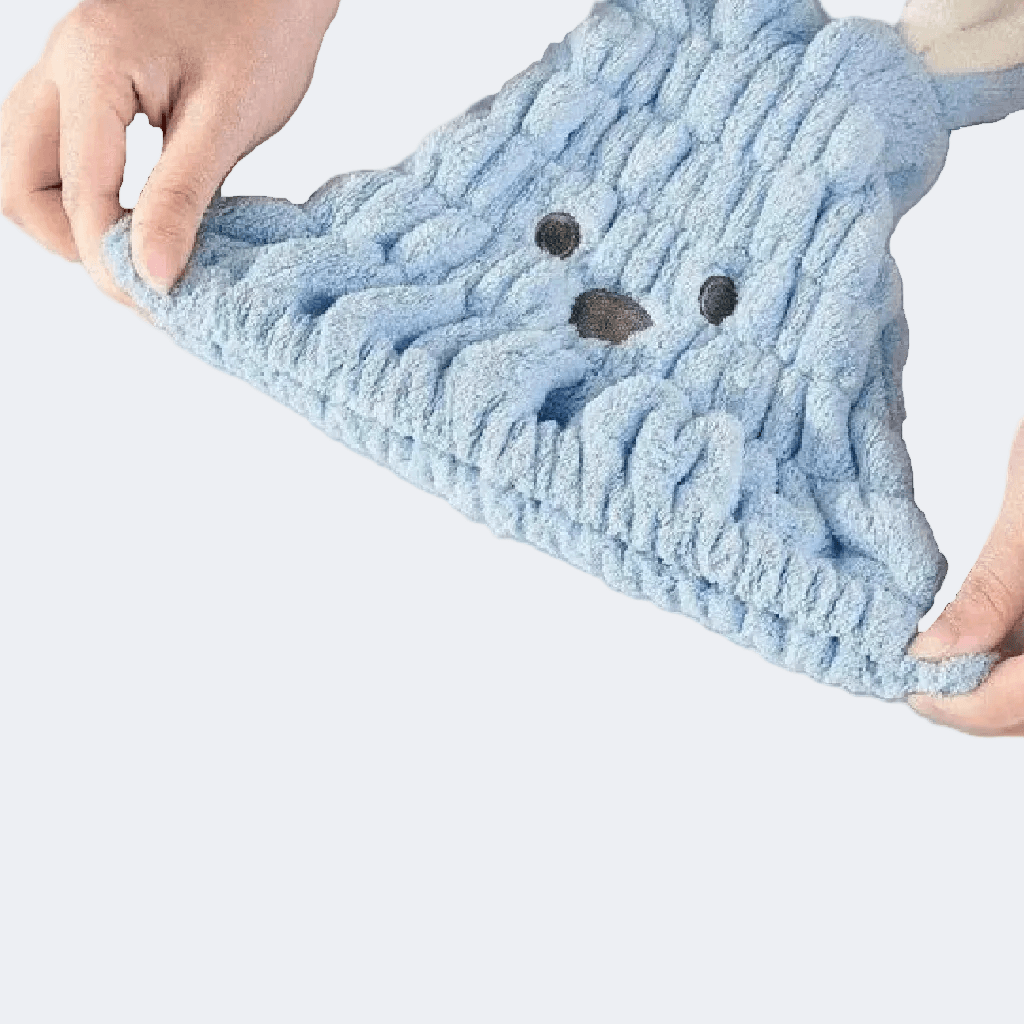 Blue knitted towel with bear face design held by hands on a white background