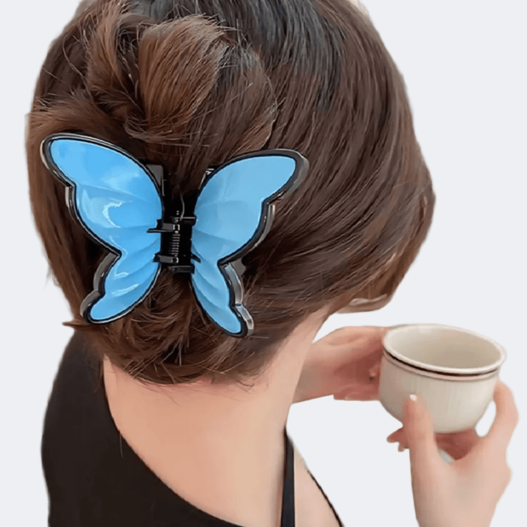 Person with blue butterfly hair clip holding a cup on a white background