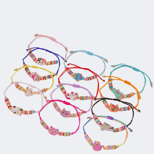 Colorful bracelets with cat charms on a pink background