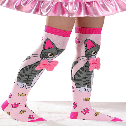Pink knee-high socks with cat design worn by a person in a pink skirt.