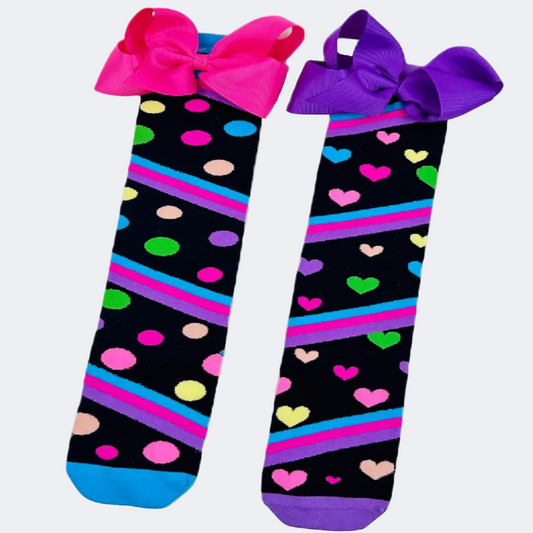 Two pairs of socks with colorful patterns and bows on a white background