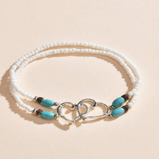 Bracelet with white beads and turquoise stones on a beige background