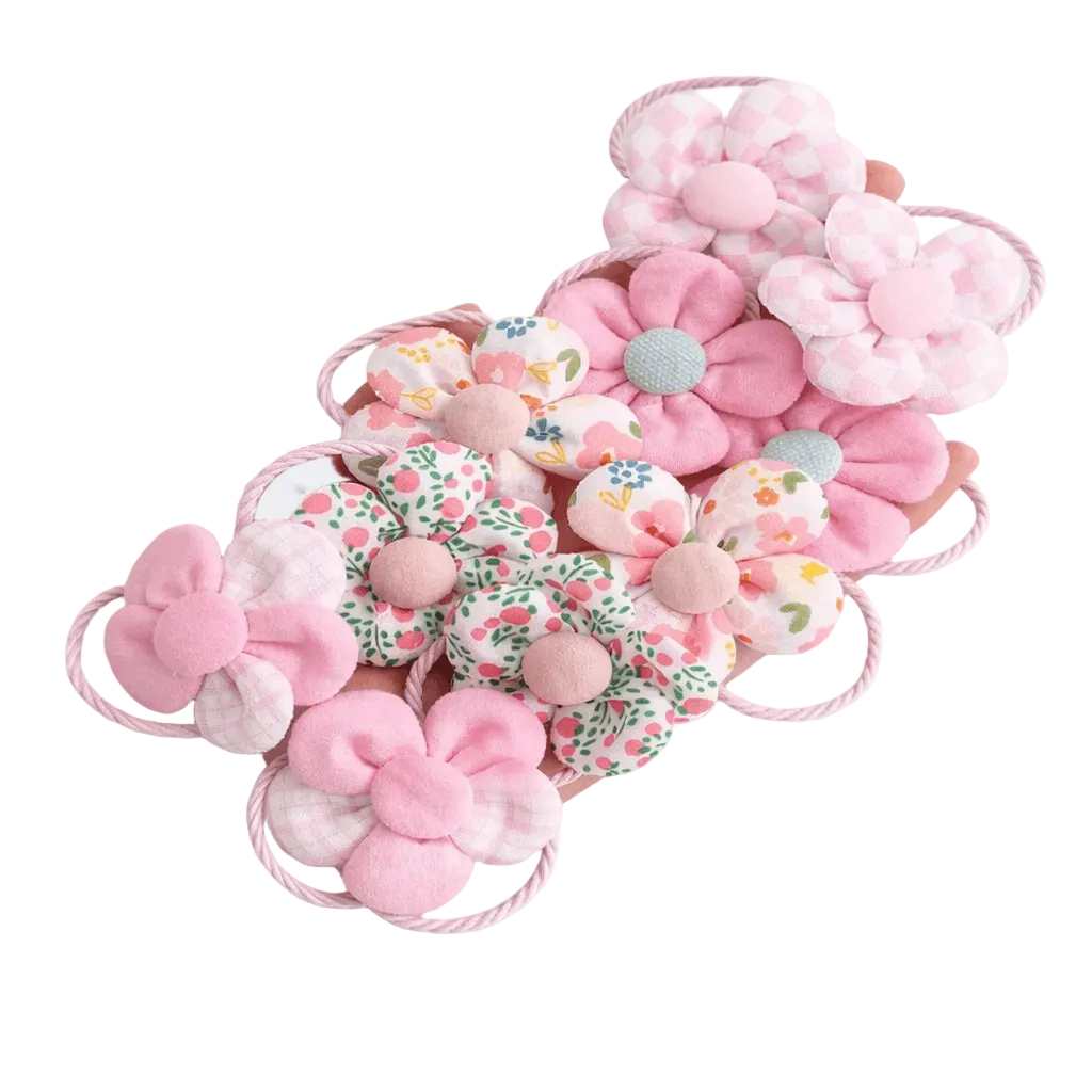Set of pink floral hair accessories on a light gray background