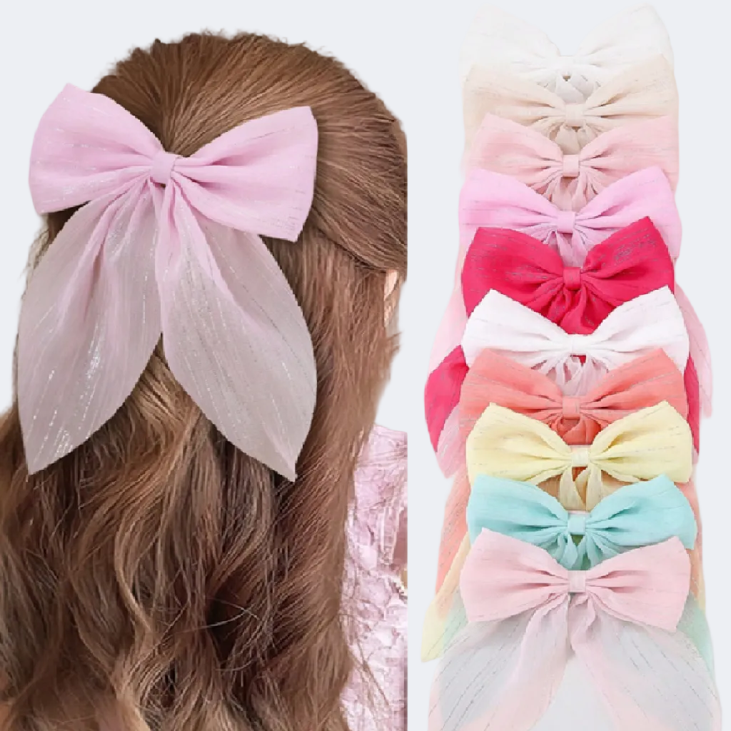 Pastel-colored hair bows on a person's head and stacked together.