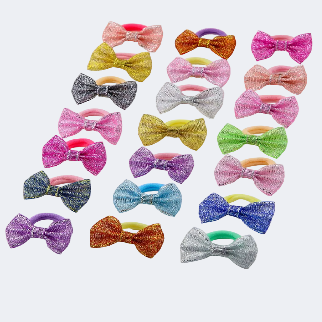 Assorted colorful glittery bow hair ties on a light background