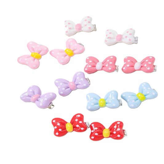 Set of colorful bow-shaped hair clips on a white background