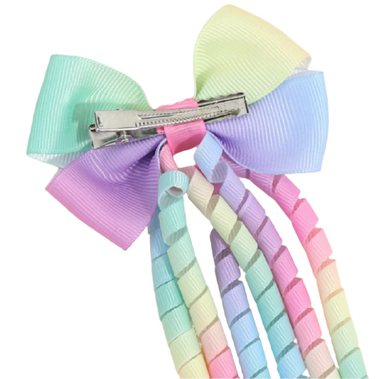 Pastel colored bow with a clip on a light background