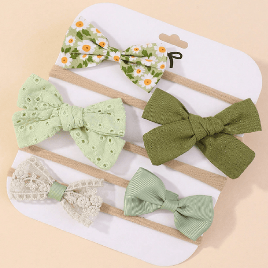 Set of green hair bows on white card with beige background