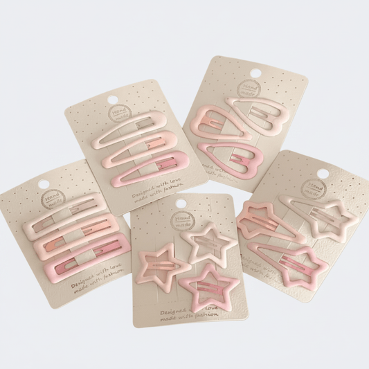 Set of pink hair clips on beige cards against a white background