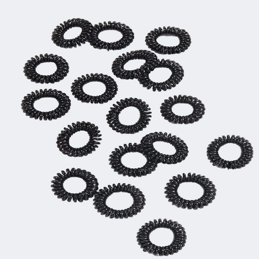 Multiple black hair ties arranged on a white background