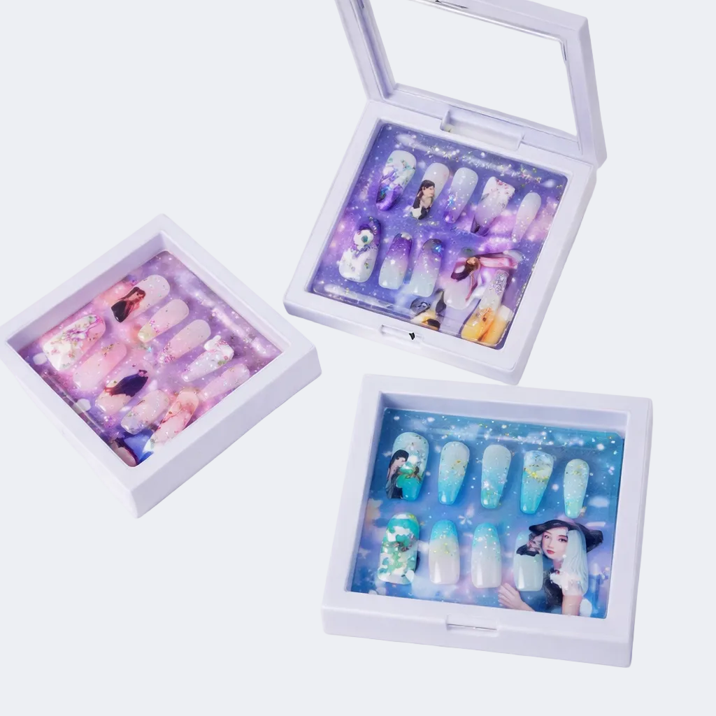 Three nail art display boxes with illustrated nail designs on a white background