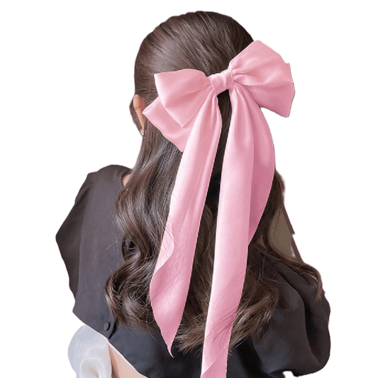 Person with long dark hair wearing a large pink bow in the back on a white background