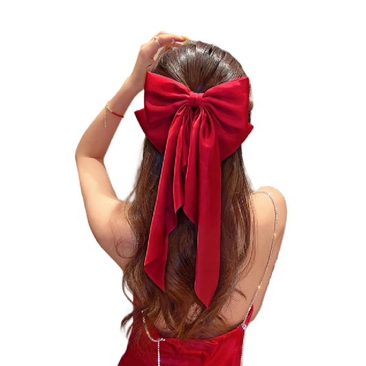 Person wearing a large red bow in their hair on a white background