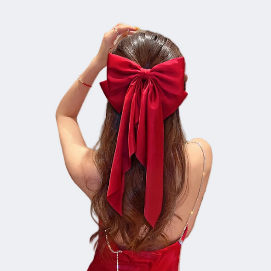 Person wearing a large red bow in their hair on a white background