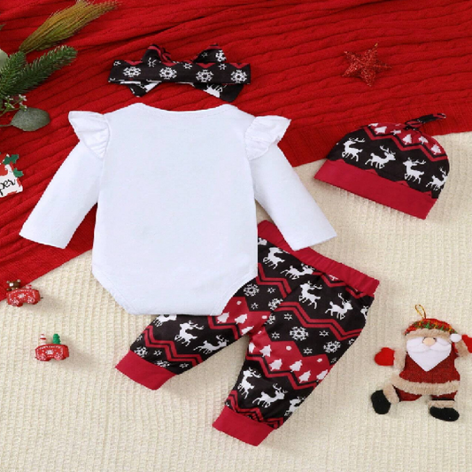 Christmas-themed baby outfit with white top, red and black patterned pants, and matching hat on a red blanket.