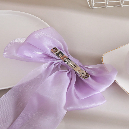Purple napkin with a decorative clip on a white plate