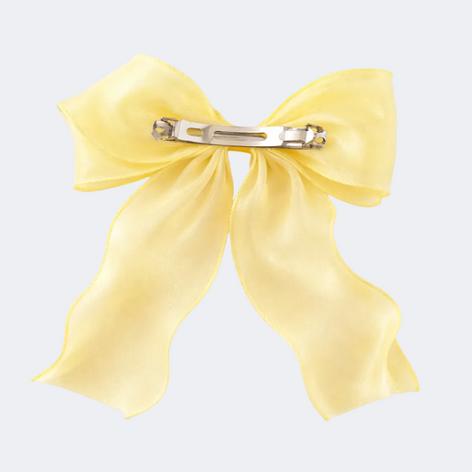 Yellow bow hair clip on a white background