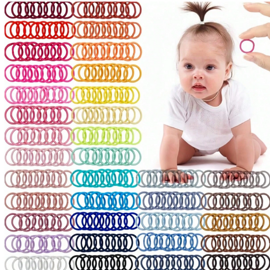 Baby with colorful hair ties and a hand holding a pink hair tie.