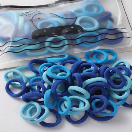 Blue and green hair ties in a clear plastic bag on a white background