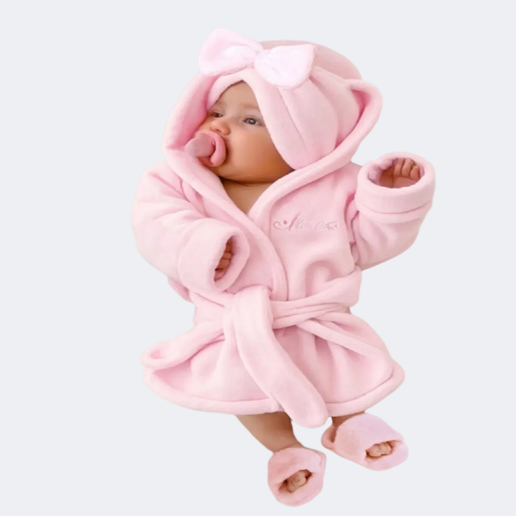 Baby wrapped in a pink robe with hat and slippers
