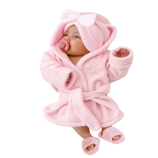 Baby wrapped in a pink robe with hat and slippers