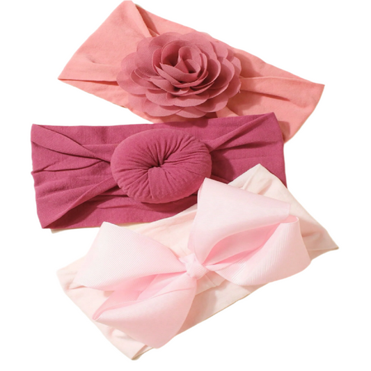 Three pink headbands with floral and bow designs