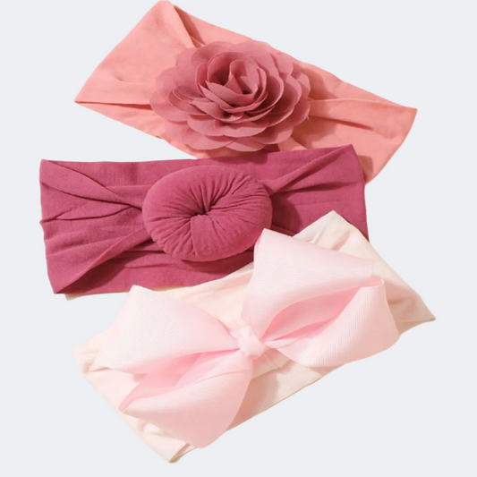 Three pink headbands with floral and bow designs