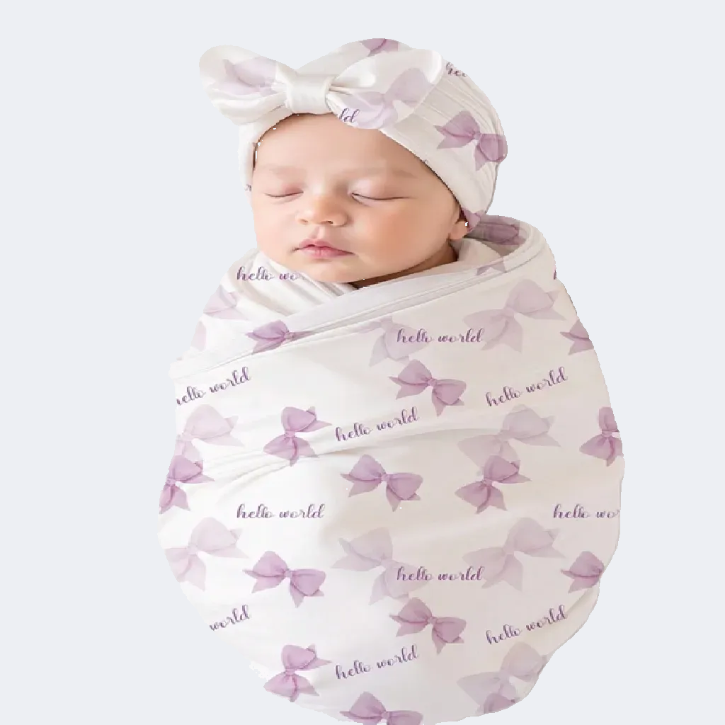 Newborn baby wrapped in a 'hello world' swaddle with a matching headband