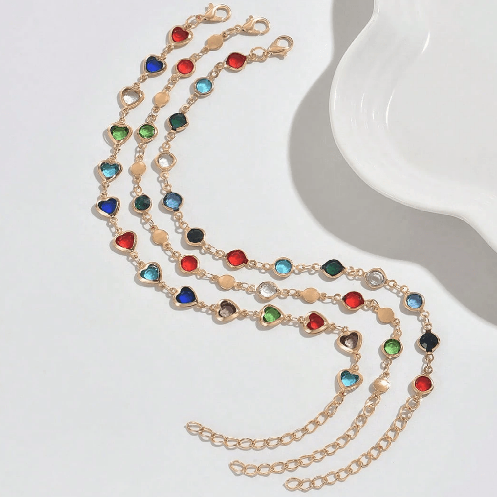 Gold necklace with colorful gemstones on a white surface
