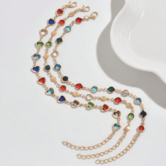 Gold necklace with colorful gemstones on a white surface