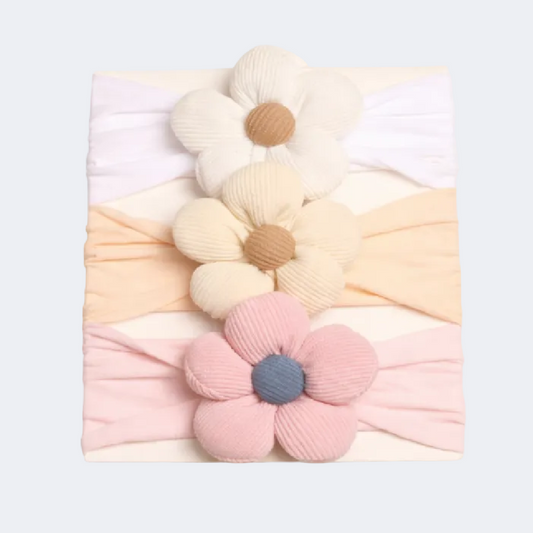 Three decorative headbands with floral designs on a light gray background