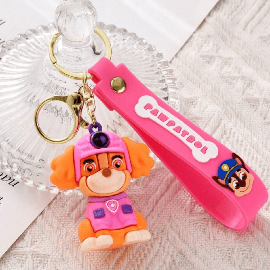Pink keychain with a character from Paw Patrol on a textured surface