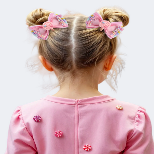 Child styled in buns with pink bows