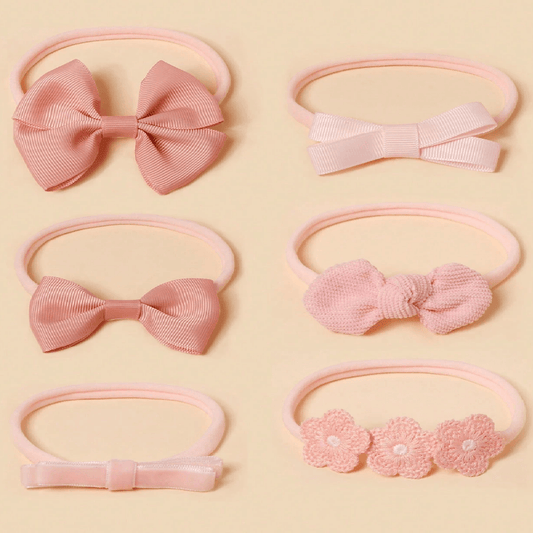 Set of pink hair accessories including bows and floral designs on a beige background