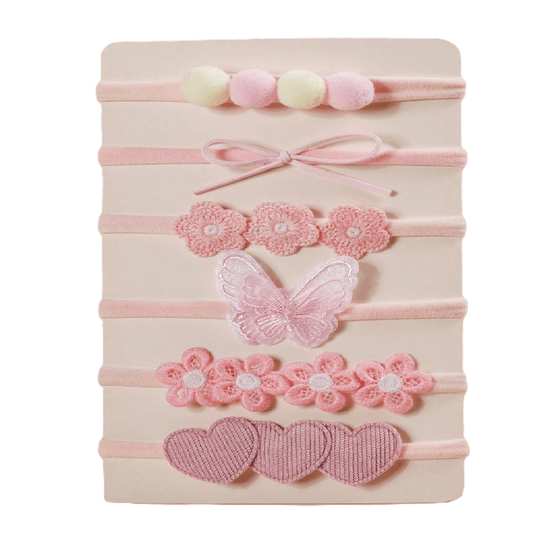Set of pink hairbands with floral and butterfly designs on a beige background
