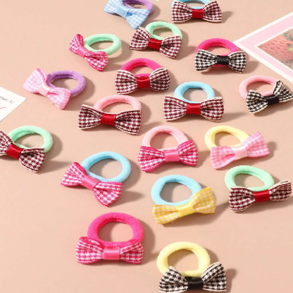 Collection of colorful hair ties with bows and checkered patterns on a beige background