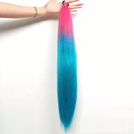 Colorful hair extensions with pink and blue gradient held by a hand on a white background